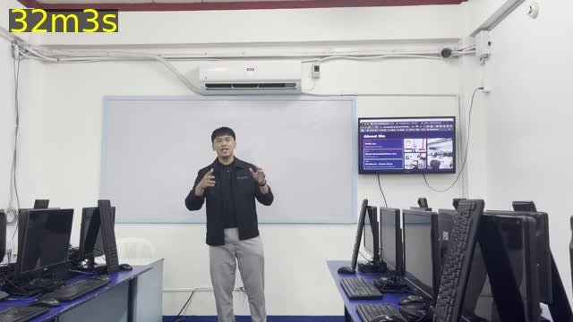 Joshua Cervantes teaching a full class of students in a computer lab